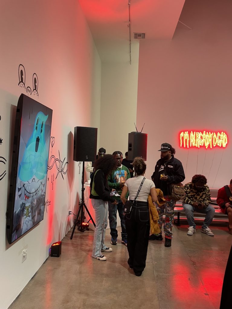 TV positioned vertically next to red uplights for an art gallery in Los Angeles